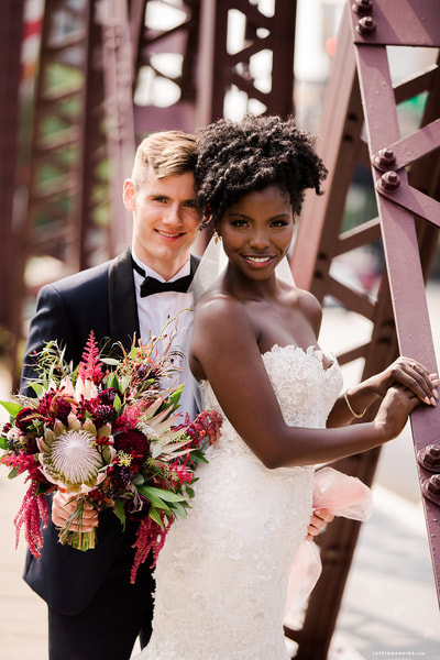 Black bride and white groom on bridge