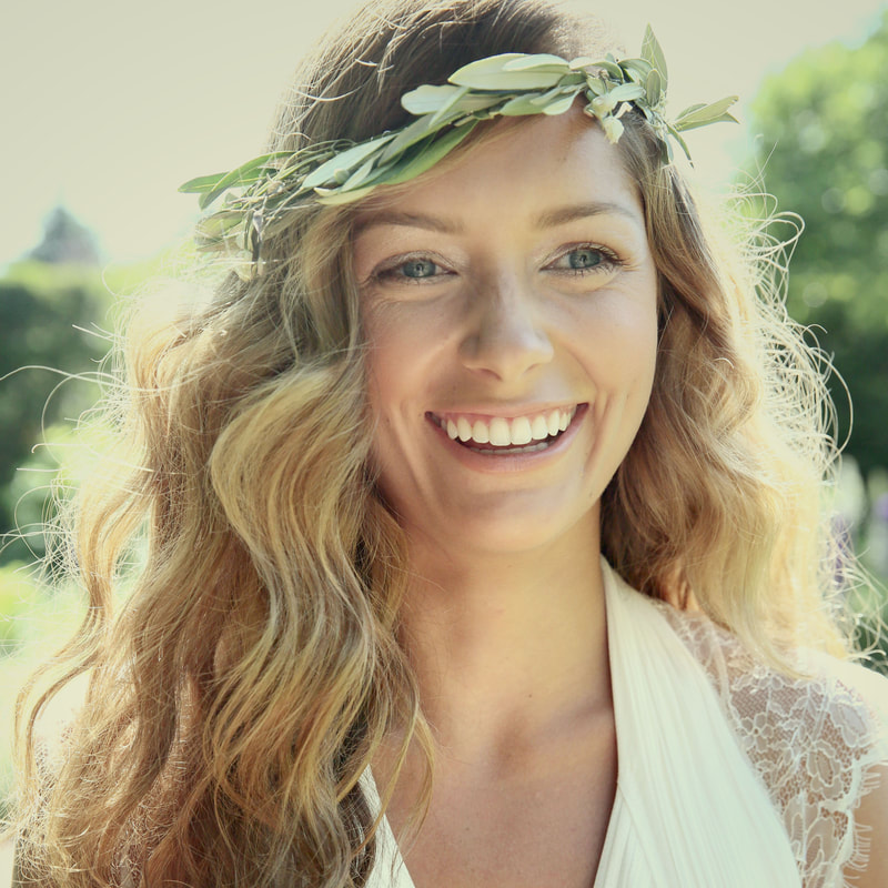Smiling blonde bride with green floral crown and beachy waves hair style 
