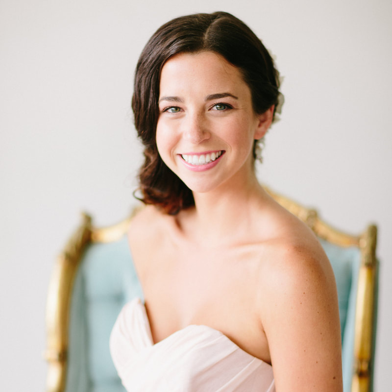 Brunette bride smiling in blue chair