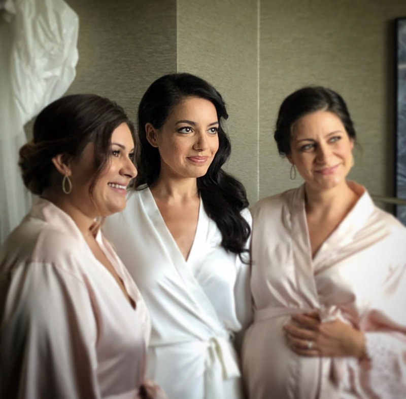 Bride with bridesmaids getting ready for wedding in robes.